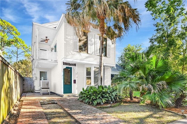 view of front of house featuring fence and a balcony