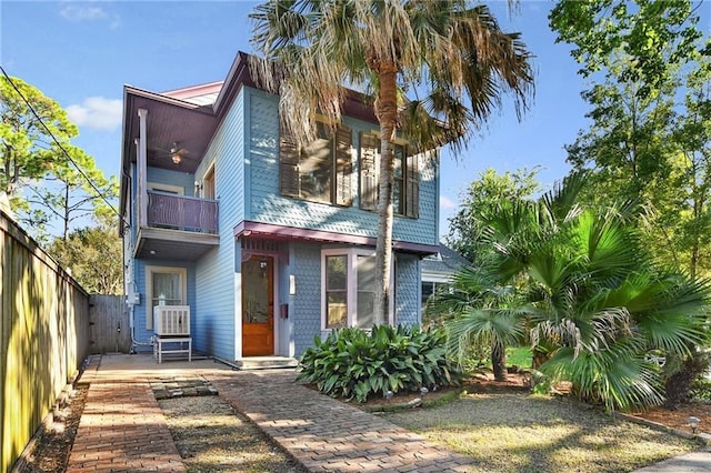 view of front of property featuring a balcony and fence