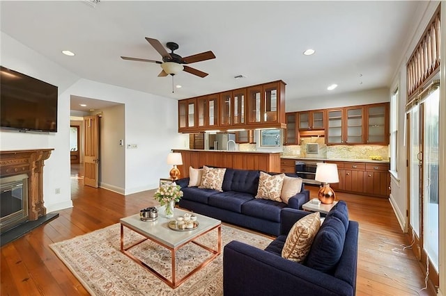 living room featuring a ceiling fan, hardwood / wood-style floors, and recessed lighting