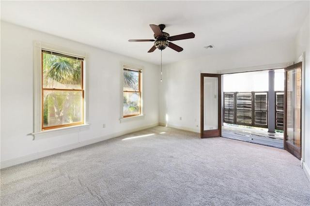 spare room featuring visible vents, baseboards, a ceiling fan, and carpet