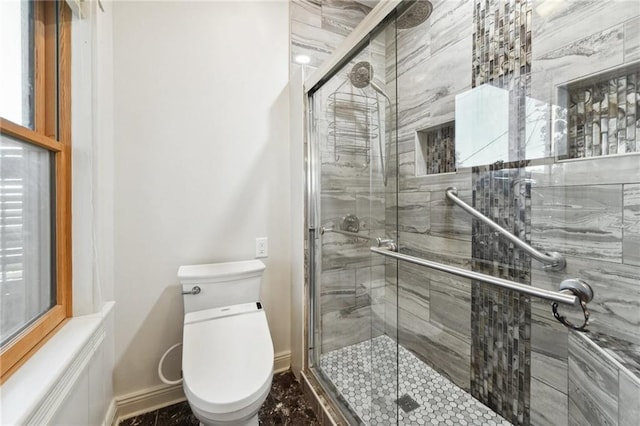 full bath featuring toilet, baseboards, and a shower stall