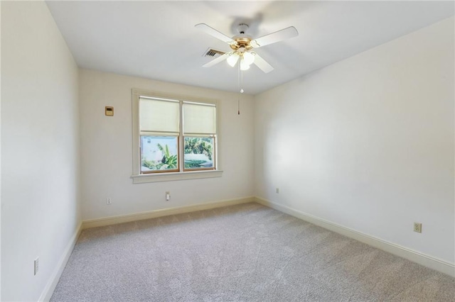 empty room featuring light carpet, baseboards, a ceiling fan, and visible vents