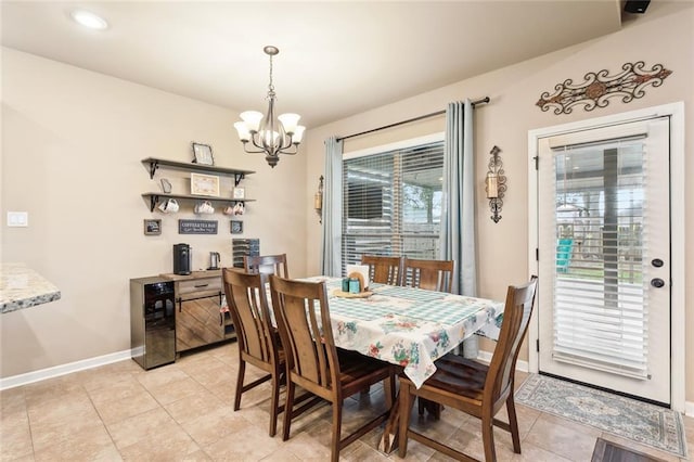 dining area featuring light tile patterned floors, baseboards, an inviting chandelier, and wine cooler