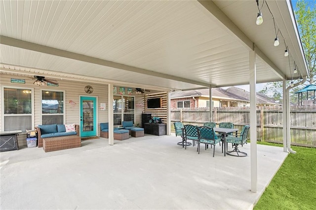 view of patio with outdoor dining area, fence, a ceiling fan, and an outdoor hangout area