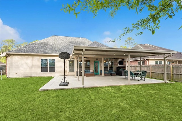 rear view of property featuring ceiling fan, a yard, a patio, roof with shingles, and fence