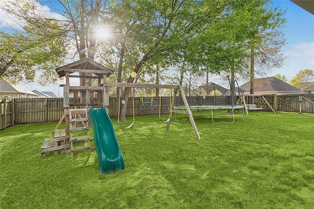 view of play area with a trampoline, a fenced backyard, and a lawn