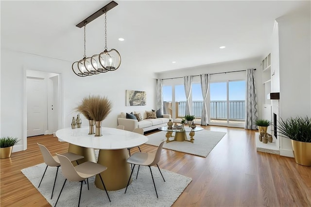 dining area featuring recessed lighting, light wood-style flooring, and an inviting chandelier