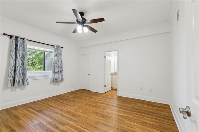 unfurnished bedroom featuring baseboards, ornamental molding, ensuite bathroom, and light wood finished floors