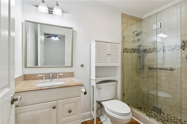 full bathroom with vanity, ornamental molding, toilet, a shower stall, and a ceiling fan
