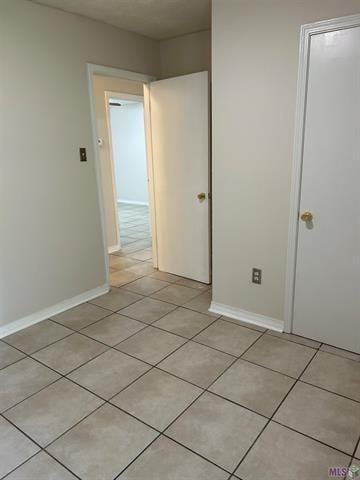 interior space with baseboards and light tile patterned floors