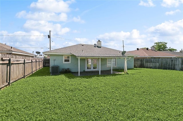 back of property featuring french doors, a fenced backyard, and a lawn