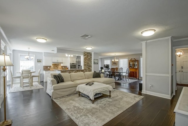 624 Fleurie Dr, Kenner, LA 70065 - living room with crown molding, visible vents, a notable chandelier, and dark wood-style floors