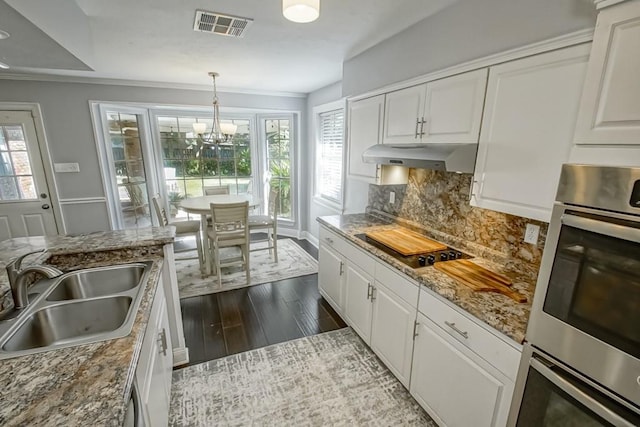 624 Fleurie Dr, Kenner, LA 70065 - kitchen with a notable chandelier, backsplash, under cabinet range hood, visible vents, and a sink