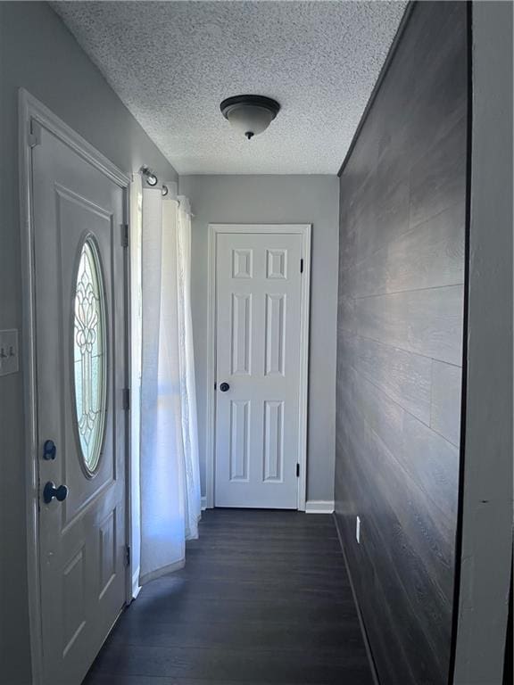 1921 Cartier Dr, La Place, LA 70068 - entryway featuring a textured ceiling, baseboards, and dark wood-type flooring
