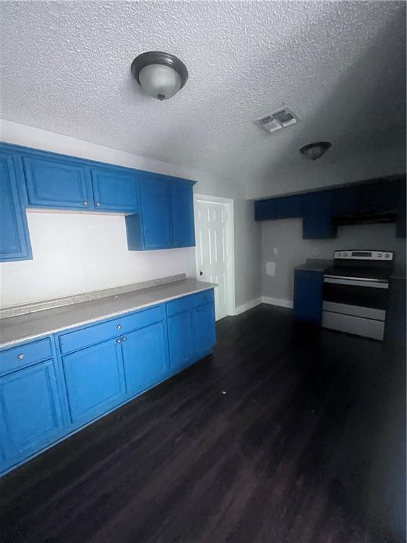 1921 Cartier Dr, La Place, LA 70068 - kitchen featuring stainless steel range with electric stovetop, a textured ceiling, dark wood-type flooring, visible vents, and blue cabinets