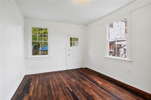 foyer with dark wood-type flooring and baseboards