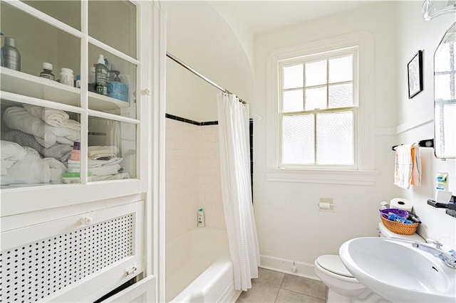 bathroom with a sink, shower / bath combo, tile patterned flooring, toilet, and baseboards