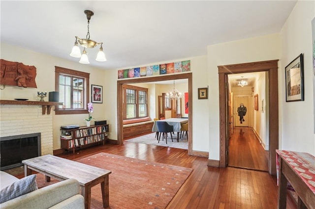 2227 Wirth Pl, New Orleans, LA 70115 - living room featuring baseboards, hardwood / wood-style floors, a chandelier, and a fireplace