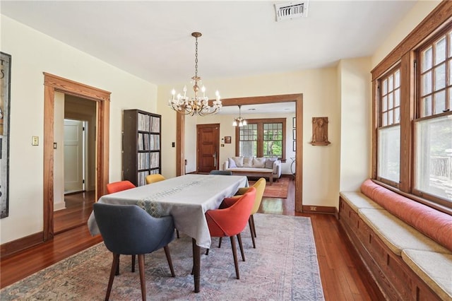 2227 Wirth Pl, New Orleans, LA 70115 - dining room featuring a chandelier, dark wood-style flooring, baseboards, and visible vents