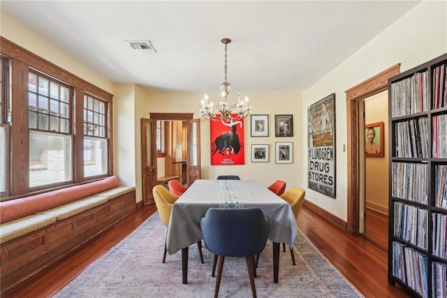 2227 Wirth Pl, New Orleans, LA 70115 - dining space with a chandelier, wood finished floors, baseboards, and visible vents