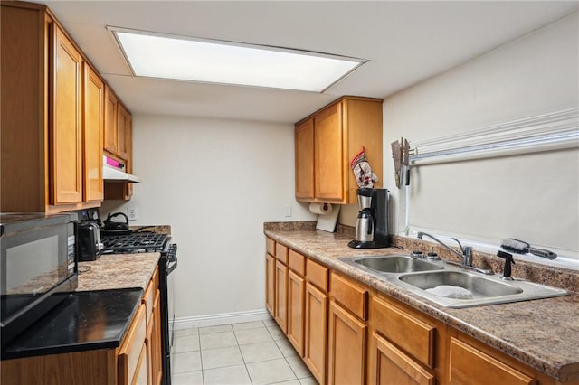 2227 Wirth Pl, New Orleans, LA 70115 - kitchen featuring stainless steel range with gas stovetop, a sink, under cabinet range hood, black microwave, and light tile patterned flooring