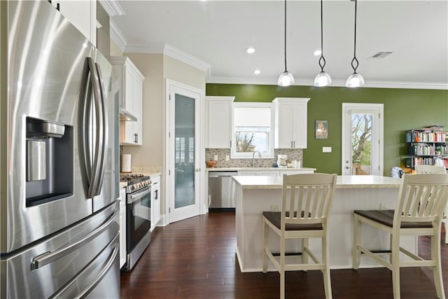 85 W Claiborne Sq, Chalmette, LA 70043 - kitchen featuring dark wood-style floors, a kitchen bar, decorative backsplash, stainless steel appliances, and a sink