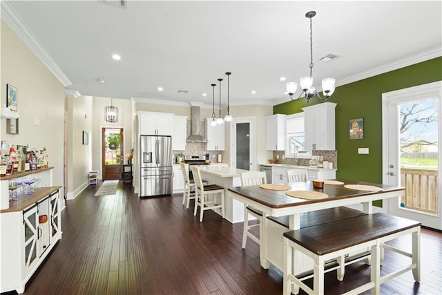 85 W Claiborne Sq, Chalmette, LA 70043 - dining room with dark wood-style flooring, a notable chandelier, ornamental molding, and visible vents