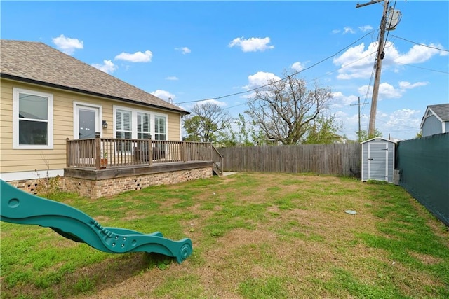 85 W Claiborne Sq, Chalmette, LA 70043 - view of yard featuring a fenced backyard, an outdoor structure, a wooden deck, and a storage unit