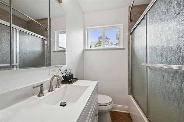 full bath with baseboards, toilet, enclosed tub / shower combo, vanity, and tile patterned floors