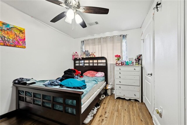 bedroom featuring visible vents, ceiling fan, and wood finished floors