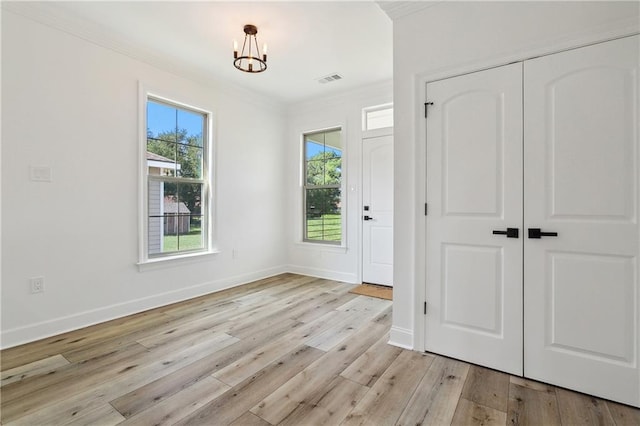 7821 Parry St, New Orleans, LA 70128 - entryway with visible vents, baseboards, ornamental molding, a chandelier, and light wood-style floors