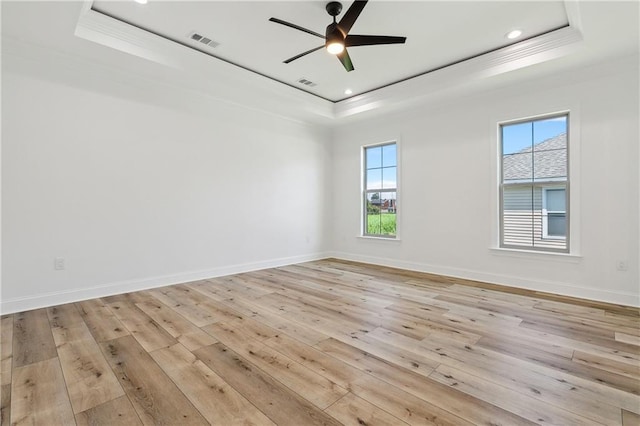 7821 Parry St, New Orleans, LA 70128 - spare room featuring light wood-type flooring, visible vents, a tray ceiling, and baseboards