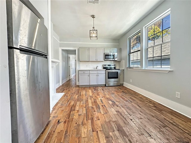 165355 Treasure St, New Orleans, LA 70119 - kitchen with stainless steel appliances, wood finished floors, plenty of natural light, and light countertops