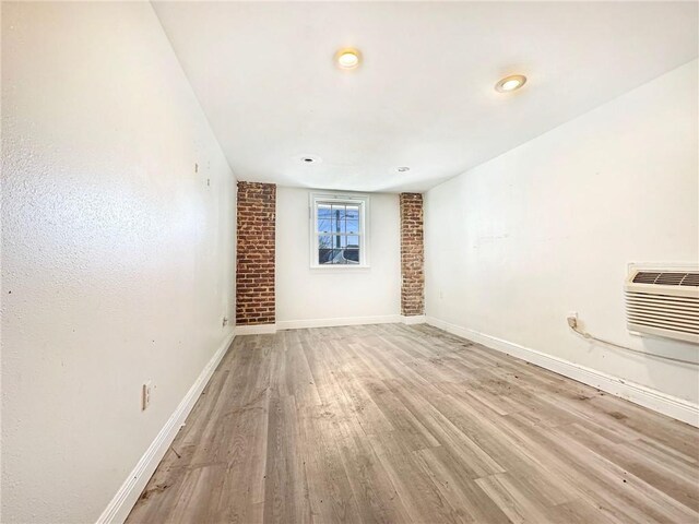 165355 Treasure St, New Orleans, LA 70119 - unfurnished room featuring light wood-style flooring, a wall unit AC, and recessed lighting