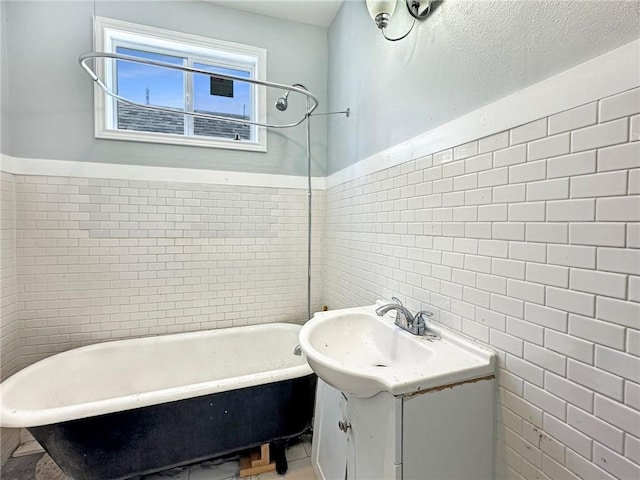 165355 Treasure St, New Orleans, LA 70119 - bathroom with a freestanding bath, tile walls, vanity, a shower, and wainscoting