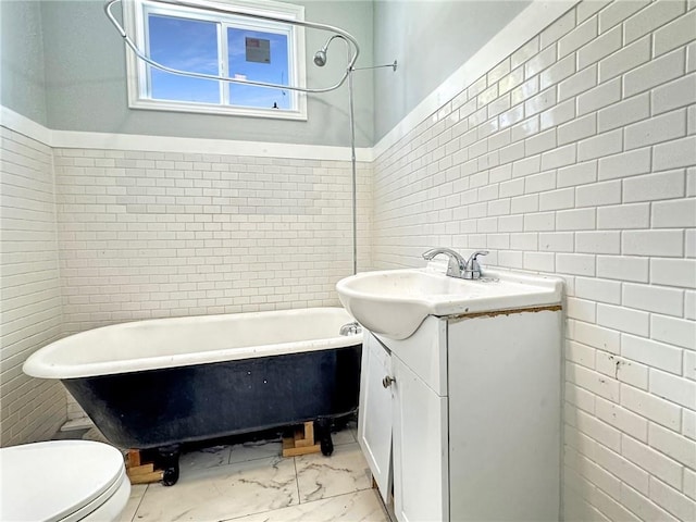 165355 Treasure St, New Orleans, LA 70119 - bathroom with tile walls, a freestanding bath, vanity, marble finish flooring, and toilet