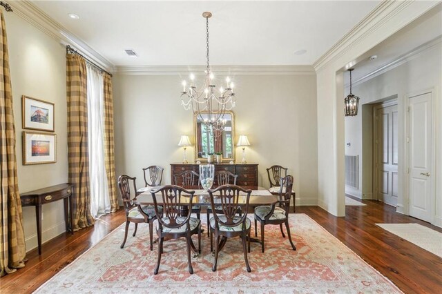 519 Homestead Ave, Metairie, LA 70005 - dining room with visible vents, ornamental molding, an inviting chandelier, and wood finished floors