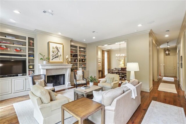 519 Homestead Ave, Metairie, LA 70005 - living room with a notable chandelier, crown molding, recessed lighting, wood finished floors, and a premium fireplace