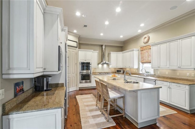 519 Homestead Ave, Metairie, LA 70005 - kitchen with wall chimney range hood, a breakfast bar, a sink, stainless steel appliances, and a center island with sink