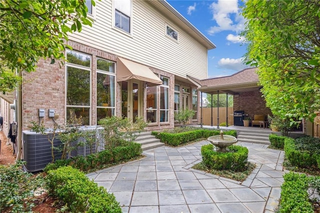 519 Homestead Ave, Metairie, LA 70005 - back of house featuring central air condition unit, a patio, and brick siding