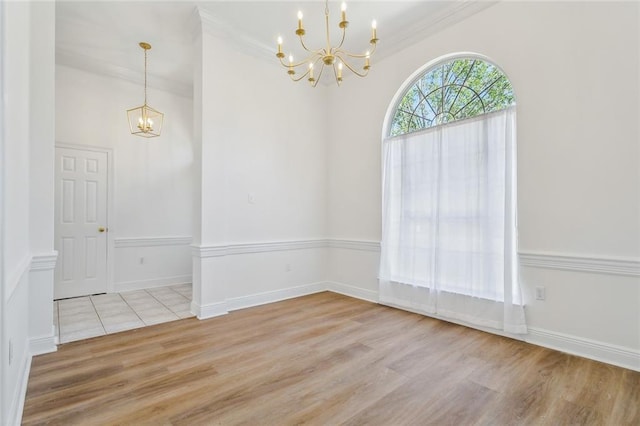 interior space featuring a chandelier, baseboards, ornamental molding, and light wood-style floors