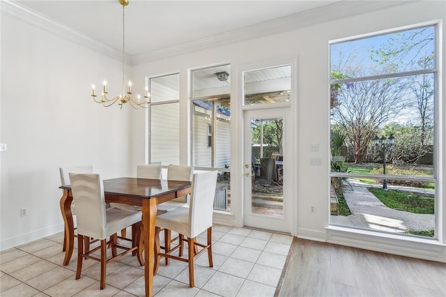dining area featuring baseboards, light tile patterned floors, an inviting chandelier, and crown molding