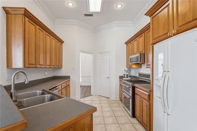 kitchen featuring a sink, appliances with stainless steel finishes, dark countertops, visible vents, and ornamental molding