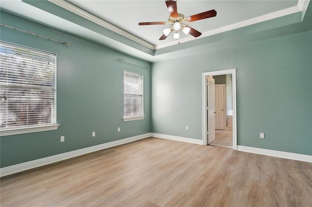 unfurnished room featuring ornamental molding, a ceiling fan, light wood-style floors, and plenty of natural light