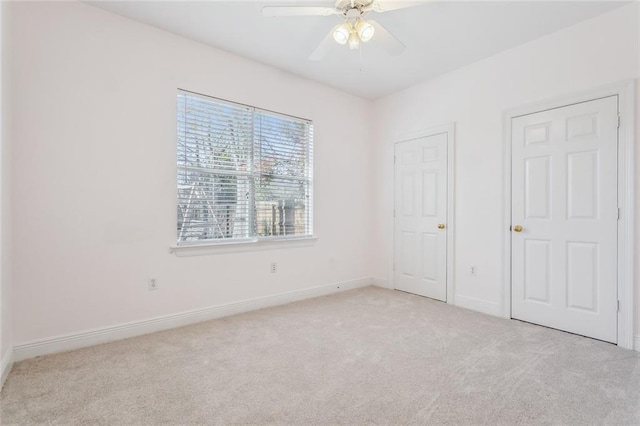 unfurnished bedroom with ceiling fan, baseboards, and light carpet