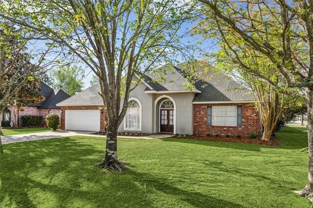 view of front of house featuring a garage, french doors, a front lawn, and driveway