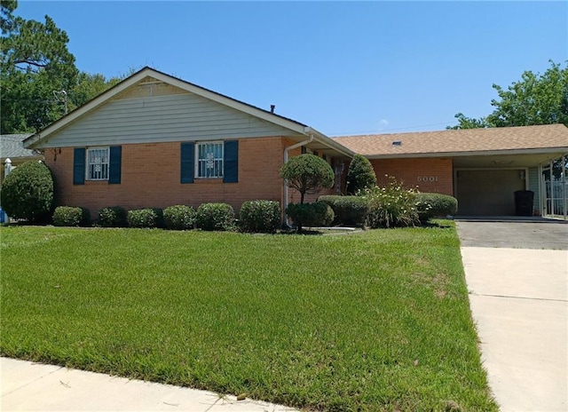 single story home with a carport, driveway, a front yard, brick siding, and a garage