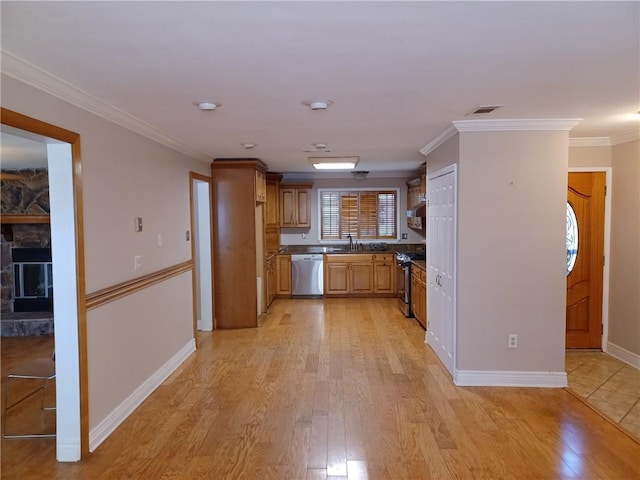 kitchen with light wood-style floors, ornamental molding, and stainless steel appliances