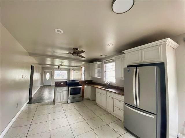 2359 Prentiss Ave, New Orleans, LA 70122 - kitchen featuring a sink, dark countertops, appliances with stainless steel finishes, a ceiling fan, and a peninsula