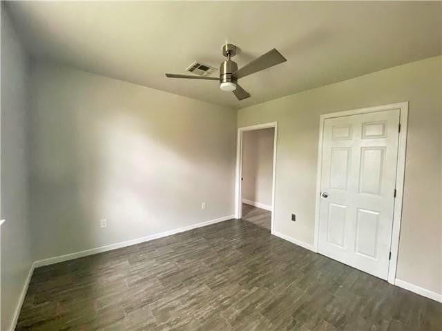 2359 Prentiss Ave, New Orleans, LA 70122 - unfurnished bedroom with dark wood-type flooring, ceiling fan, baseboards, and visible vents